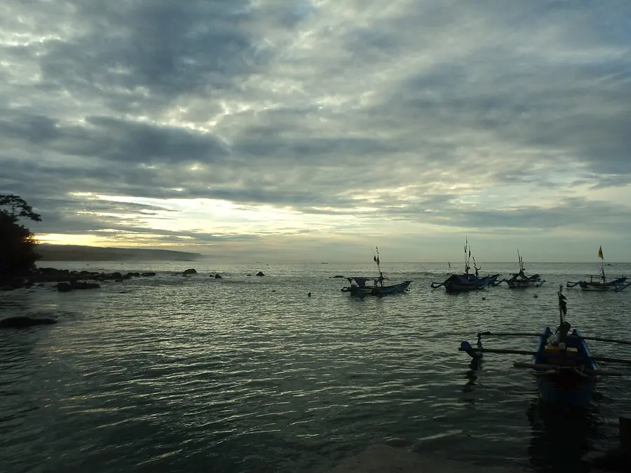 Perahu nelayan di Pantai Jayanti saat matahari terbenam